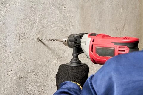 Drilling a hole in the wall with a drill Stock Photos