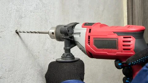 Drilling a hole in the wall with a drill Stock Photos