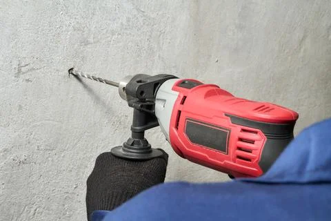Drilling a hole in the wall with a drill Foto stock
