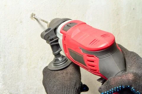 Drilling a hole in the wall with a drill Stock Photos
