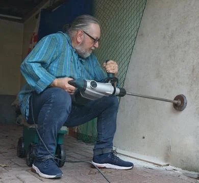 Drilling a hole in a wall Stock-Fotos
