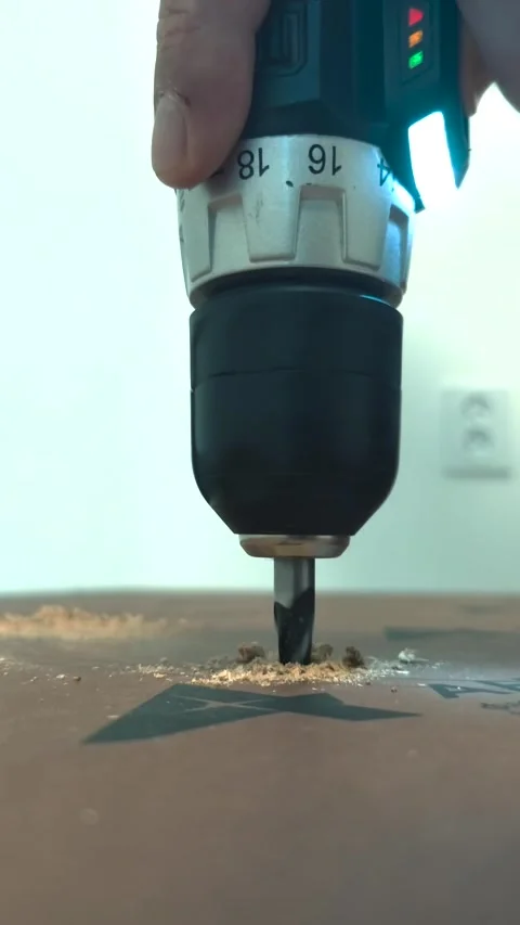 Drilling a hole in a wooden slab using an electric drill. Stock Footage 318075373