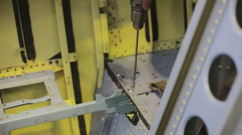 Drilling holes in body of plane between baffles with a drill bit Stock Footage 66953301