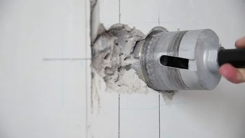 Drilling holes in a concrete wall for socket boxes with a diamond core bit Stock Footage 289524535