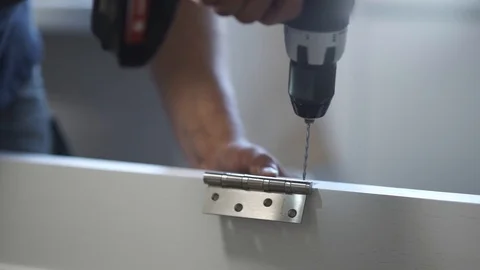 Drilling holes under the door hinge on wooden board Stock Footage 98943768