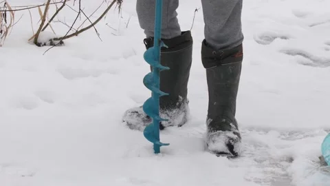 Drilling ice with an ice drill. Drilling holes in ice. Preparation before winter Stock Footage 147315661