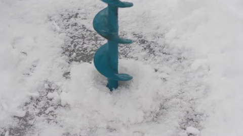 Drilling ice with an ice drill. Drilling holes in ice. Preparation before winter Stock Footage 147315809