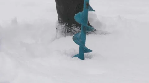 Drilling ice with an ice drill. Drilling holes in ice. Preparation before winter Stock Footage 147320332
