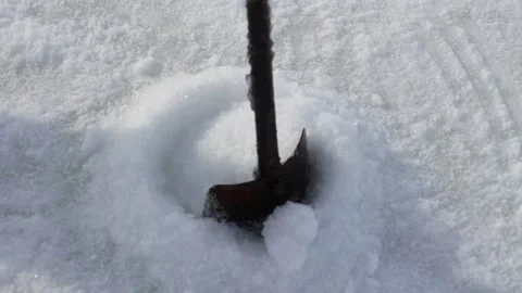 Drilling ice with an ice drill. Drilling hole in ice for fishing in winter Video stock 149592455