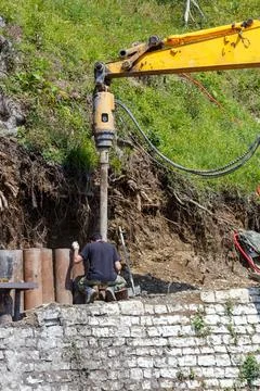 Drilling machine digging into hillside Stock Photos