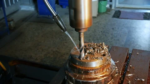 Drilling machining process in metal part on a lathe, water is pouring on drill Stock Footage 117430724