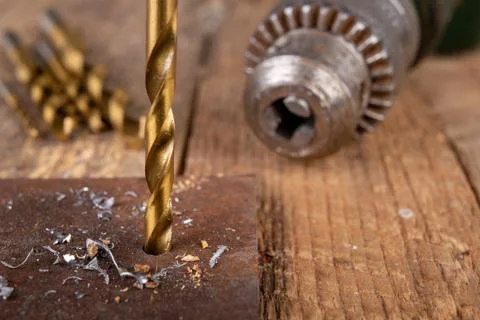 Drilling with a metal drill. Small locksmith work in the home workshop. Stock Photos
