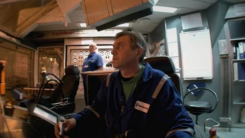 Drilling operator monitors controls inside offshore oil rig control room Stock-Footage 331501228