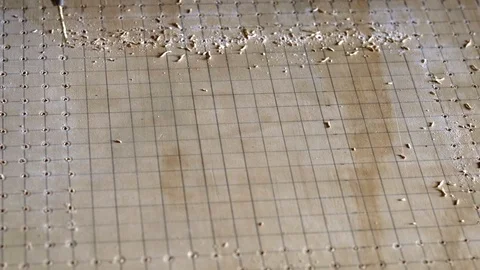 Drilling a pattern of holes using a power tool and guided by grid lines. Stock Footage 108593088
