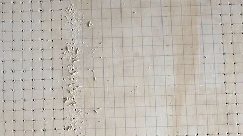 Drilling a pattern of holes using a power tool and guided by grid lines. Stock Footage 108593109