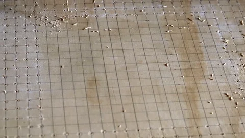 Drilling a pattern of holes using a power tool and guided by grid lines. Stock Footage 108593484