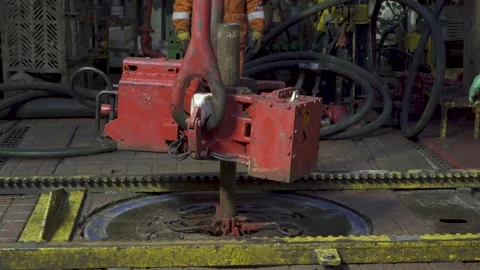 Drilling platform. Rotor table. Disassembly of pipe layout. Men in orange Stock Footage 255155980
