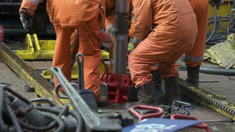 Drilling platform. Rotor table. Manual slips is being installed. Legs in orange Stock Footage 196953298