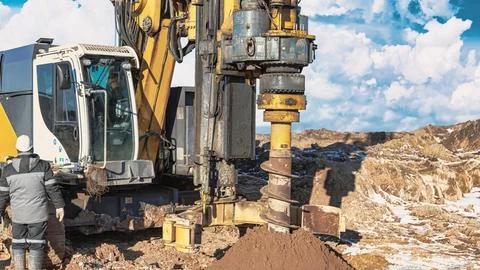 A drilling rig is actively working on a pile foundation at a construction sit Stock Photos