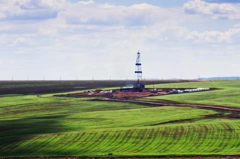 Drilling rig among green fields Stock Photos