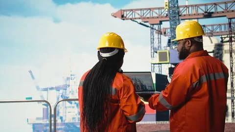 Drilling rig boat engineering team using laptop to monitor equipment systems Stock Photos