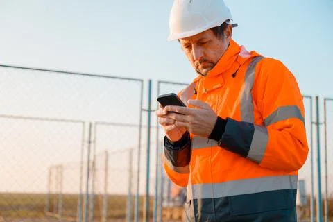 Drilling rig engineer using mobile phone while supervising the process of o.. Stock Photos