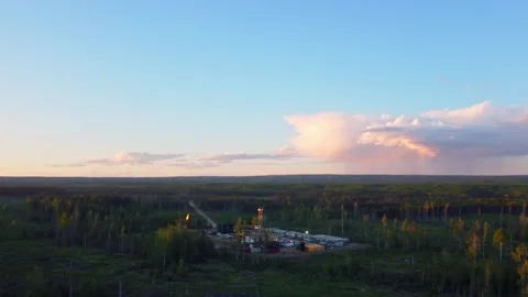 Drilling Rig in a Green Field Beneath a Blue Sky with White Clouds, Alberta Stock Footage 341914786