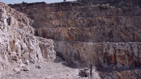 Drilling rig operating in an expansive open-plan quarry, extracting stone Stock Footage 274042516