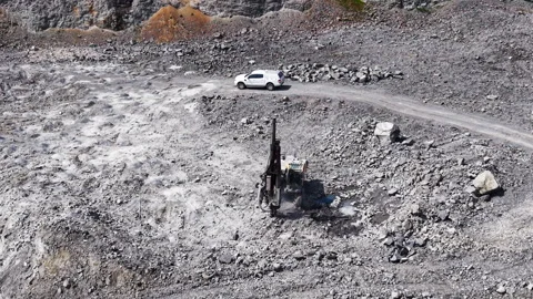 Drilling rig operating in open pit quarry, Bulgaria Stock Footage 335691413