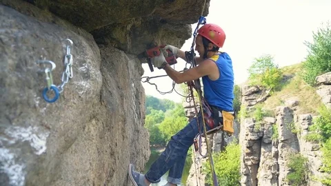 Drilling of rock, a man hangs by a sheer rock Video stock 78007041