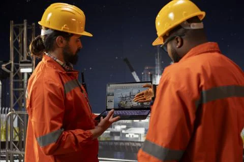 Drilling ship crew analyzing gear performance on laptop dashboard screen Stock Photos