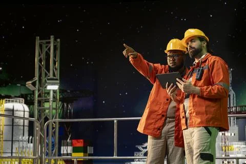 Drilling ship engineers use tablet to control subsea systems during night shift Stock Photos