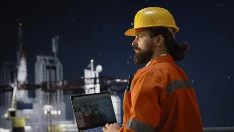 Drilling ship men using laptop to monitor defects during war causing oil crisis Stock Photos
