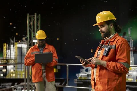 Drilling ship technician managing operational workflows using tablet app Stock Photos