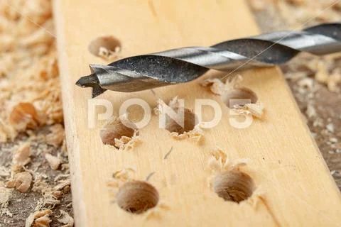 Drilling with a vane drill in chipboard. Carpentry work in a carpentry worksh Stock Photos