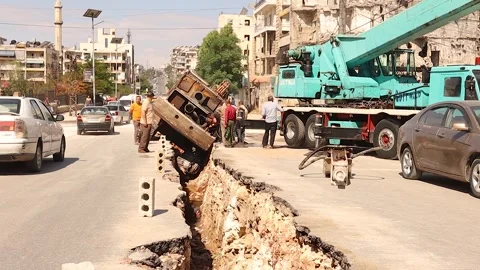 Drilling Vehicle Falls into a Pit in Aleppo as Syrians Struggle to Rescue It Stock Footage 295040608