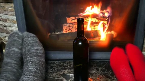 Drink alcohol at the fireplace from the glasses Stock Footage 99490030