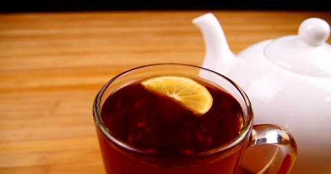 Drink black tea in a transparent cup and teapot Stock Footage 143122169