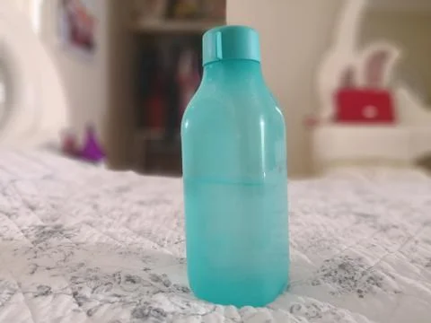 Drink bottle sitting on bed Stock Photos