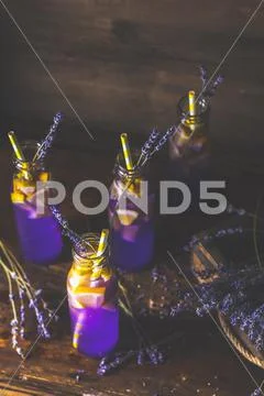 Drink bottles glass with lavender cocktail on a dark rustic style Stock Photos