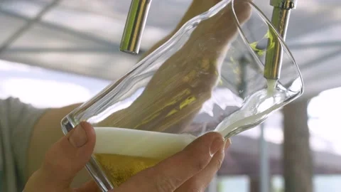 The drink bubbles and foams. A man pours beer into a glass Video stock 235485337
