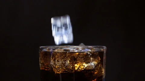 Drink with bubbles in a glass. Ice cubes fall into a glass. Stock Footage 133160982