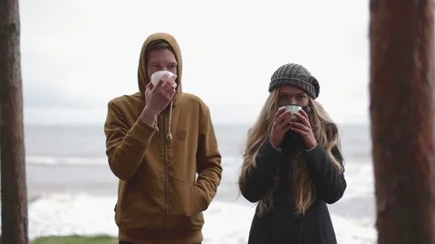 Drink in cold weather. man and woman drink tea from a thermos Stock Footage 70772448