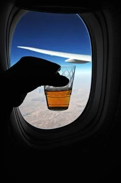 Drink Glass in a Hand at flight window Stock Photos