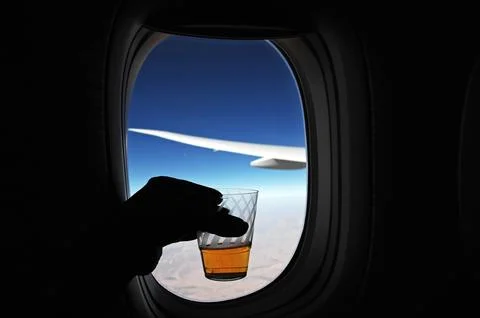Drink Glass in a Hand at flight window Stock Photos