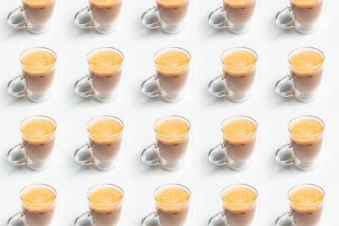 Drink pattern of double walled glass mug with coffee and vegan milk on white  Foto stock