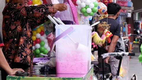 Drink vendor preparing Es campur a typical Indonesian drink in the street Stock Footage 246911892