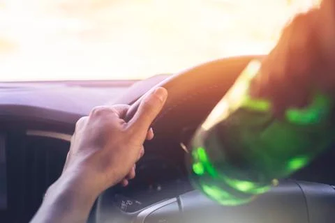 Drinking and driving ,man drinking alcohol while driving car Stock Photos