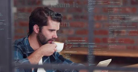 Drinking bearded man in blue-plaid shirt holding cup and reading tablet at cafe, 스톡 사진
