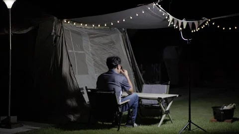 Drinking a Beverage at a Backyard Campsite at Night Stock-Footage 346534062